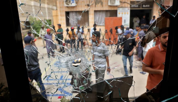 Members of media are seen through a broken glass window inside the premises of the district Malir jail after dozens of prisoners escaped from the jail on the outskirts of Karachi, Pakistan, June 3, 2025. — Reuters